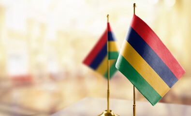Small flags of the Mauritius on an abstract blurry background