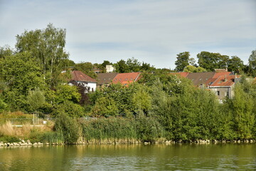 Le lac principal avec quelques lotissements résidentiels autour dissimulés derrière la végétation luxuriante du parc du Paradis à Braine l'Alleud en Brabant Wallon 