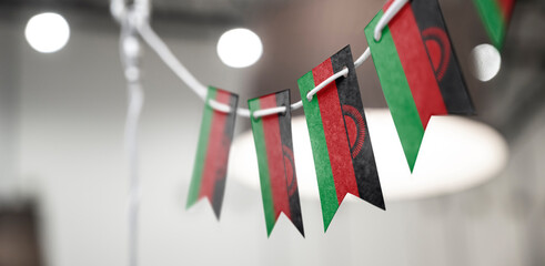 A garland of Malawi national flags on an abstract blurred background