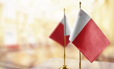 Small flags of the Malta on an abstract blurry background