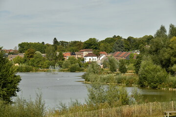 Le lac principal avec quelques lotissements résidentiels autour dissimulés derrière la végétation luxuriante du parc du Paradis à Braine l'Alleud en Brabant Wallon 