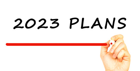 Hand writing 2023 PLANS with red marker. Isolated on white background.