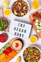 Vegan or veganuary feast with various salads ad healthy plates on light gray table