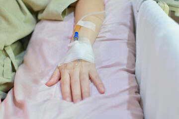 Fototapeta na wymiar Patient's hands with saline solution lying on the hospital bed