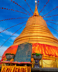 Message in Thai on stone board by golden stupa in Buddhist temple at