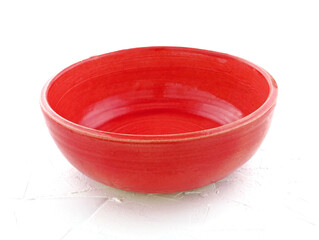 Epty Red ceramic bowl on a white background. Colored ceramic dishes close-up handmade. Hobby ceramics earthenware. Bright utensils for food.