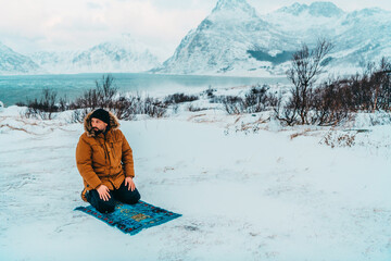 A Muslim traveling through arctic cold regions while performing the Muslim prayer namaz during breaks