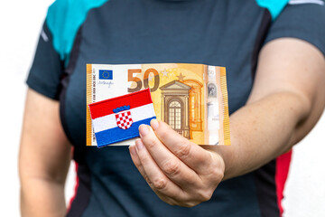 Croatian woman holding a flag in front of her. The symbol of Croatia and the euro banknote, The...