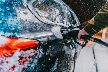 Refuelling diesel gas on petrol station at winter