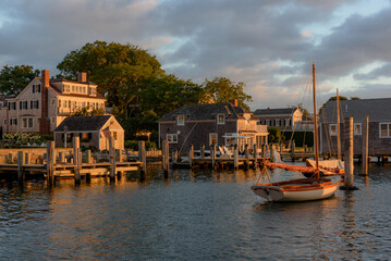 Golden hour sunrise along the Edgartown harborfront.  Sailboats, docks and homes are bathed in a...