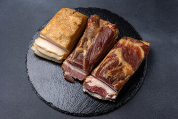 Traditional Ukrainian meat delicacies, snacks. Cold boiled pork on a dark table