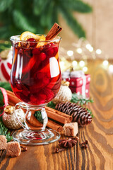 Christmas hot mulled wine. Glasses of mulled wine with aromatic spices cinnamon, anise, sugar and fir tree branches with bokeh and decorations. Traditional Xmas festive drink. Winter Christmas drink.
