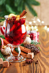 Christmas hot mulled wine. Glasses of mulled wine with aromatic spices cinnamon, anise, sugar and fir tree branches with bokeh and decorations. Traditional Xmas festive drink. Winter Christmas drink.