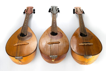 Three old mandolins isolated on a white background. Selective focus.