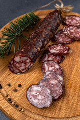Traditional meat delicacies, sausages on a dark table
