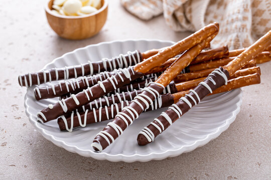 Chocolate covered pretzel rods homemade on a white plate