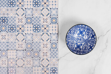 blue patterned tile with blue bowl on marble background