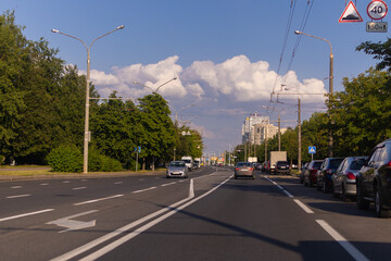 Fototapeta na wymiar Highway wide road in the city, transport and blue sky with clouds on a summer day