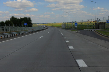 Fototapeta premium Highway wide road in the city, transport and blue sky with clouds on a summer day