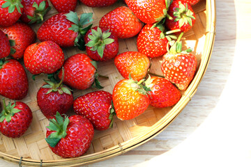 Red strawberries spread in bamboo baskets on white background. soft and selective focus.