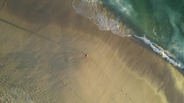 Aerial view of a person walking on the beach at Playa del Divorcio, Cabo San Lucas, Baja California, Mexico.