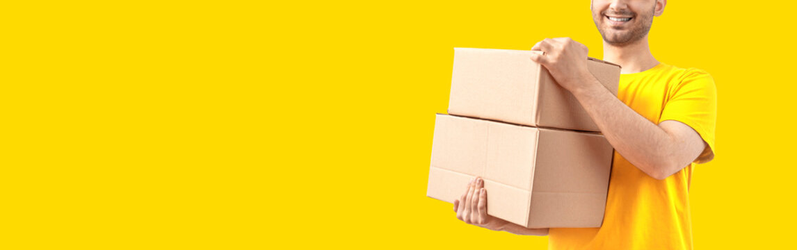 Delivery Man With A Box. Courier In Uniform T-shirt Service Fast Delivering Orders. Young Guy Holding A Cardboard Package. Character On Bright Isolated Background For Mockup Design