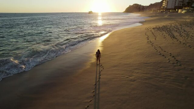 Aerial view of a person walking on the beach at Playa del Divorcio, Cabo San Lucas, Baja California, Mexico.