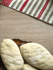 pies made of dough on a wooden board on the background of a woven towel