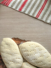 pies made of dough on a wooden board on the background of a woven towel