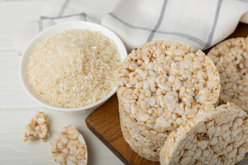 Rice cakes on a white texture table, against the background of a plate of rice. Close-up. Healthy food. Diet food.