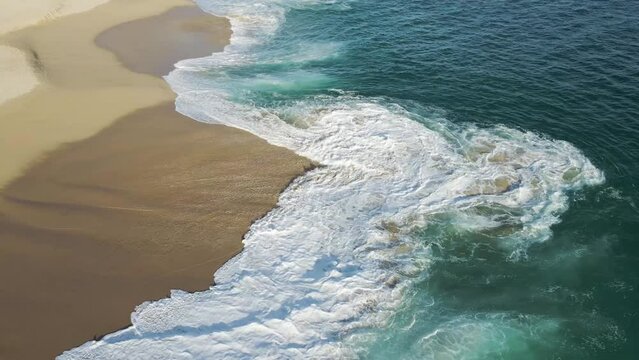 Aerial view of waves breaking on the shoreline at Playa del Divorcio, Cabo San Lucas, Baja California, Mexico.