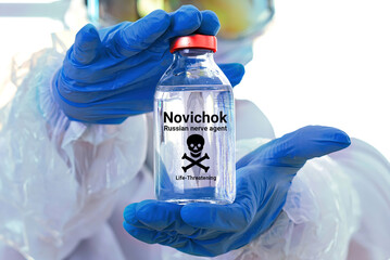 Person in chemical protection demonstrating a flask of colorless liquid. Fake designation 
