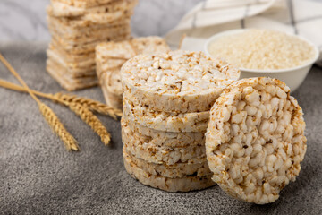 Rice cakes on a black texture table, against the background of a plate of rice. Close-up. Healthy...
