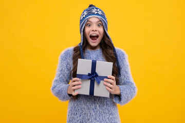 Funny kid girl in winter wear holding gift boxes celebrating happy New Year or Christmas. Winter holiday. Excited teenager girl.