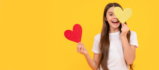 Obraz na płótnie Canvas teen girl on yellow background. love present. surprised kid with love romantic gift. Kid girl portrait with heart love symbol, horizontal poster. Banner header with copy space.