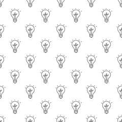 Seamless pattern with hand drawn small black light bulbs on a white background.