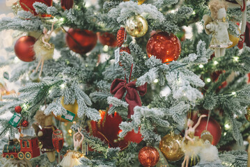 Fototapeta premium Decorated Christmas tree on blurred background, Christmas background - baubles and branch of spruce tree