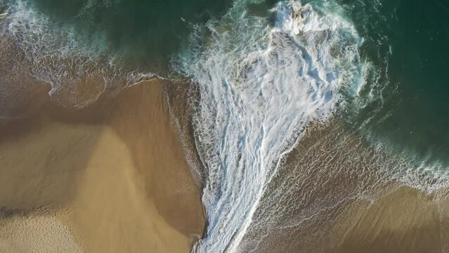 Aerial view of waves breaking on the shoreline at Playa del Divorcio, Cabo San Lucas, Baja California, Mexico.