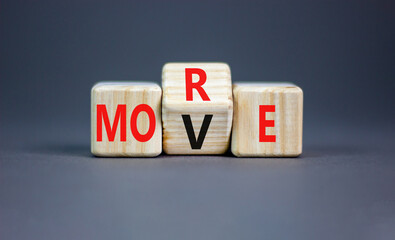 More move symbol. Concept word More move on wooden cubes. Beautiful grey table grey background....