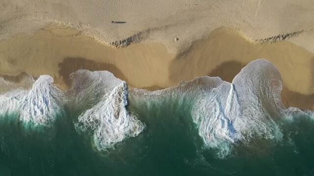 Aerial view of waves breaking on the shoreline at Playa del Divorcio, Cabo San Lucas, Baja California, Mexico.