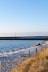 Fototapeta premium Sunny beach front in the winter, sand and people on the beach