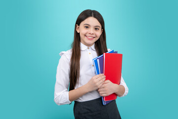 Back to school. Teenager schoolgirl with book ready to learn. School girl children on isolated blue studio background.