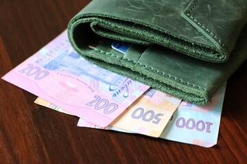 Ukrainian paper money in two hundred, five hundred and one thousand hryvnia bills. Green wallet.