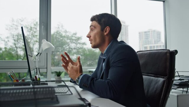 Handsome freelancer talking online at remote workplace. Office manager calling
