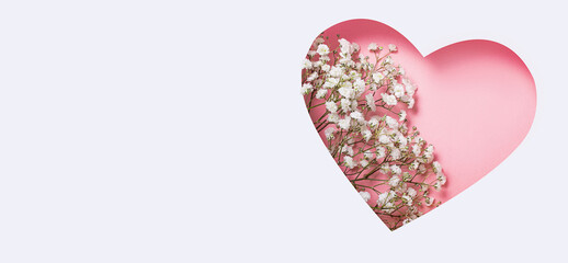 Heart with white wild flowers on a light background. Flowers in the shape of a heart. Postcard for March 8, St. Valentine's Day, Women's Day. Banner. Copy space.
