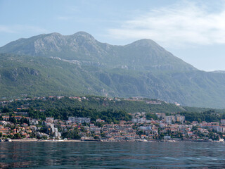 Fototapeta premium Seascape with seaside town in mountains view from open sea