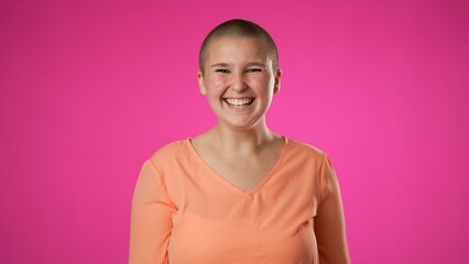 Young excited fun gender fluid non binary woman 20s look camera laugh smiling point index finger on you isolated on pink background studio portrait People lifestyle concept