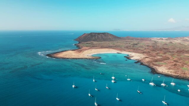 Stunning high level aerial panning clip of the beautiful secluded bay and tropical looking island of Lobos near Corralejo Fuerteventura