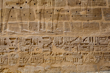 Hieroglypic painted carvings on wall at the ancient egyptian temple in Luxor. Egypt.
