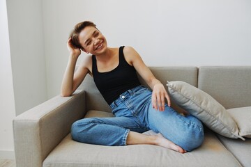 Young woman with short haircut hair having fun at home on the couch smile and happiness, vacation...